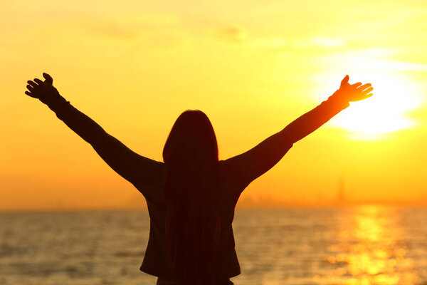 Портрет женщины, празднующей отдых на закате на пляже
