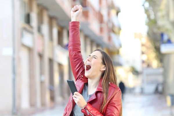 Opgewonden Vrouw Met Smart Phone Viert Succes Verhogen Arm Straat — Stockfoto