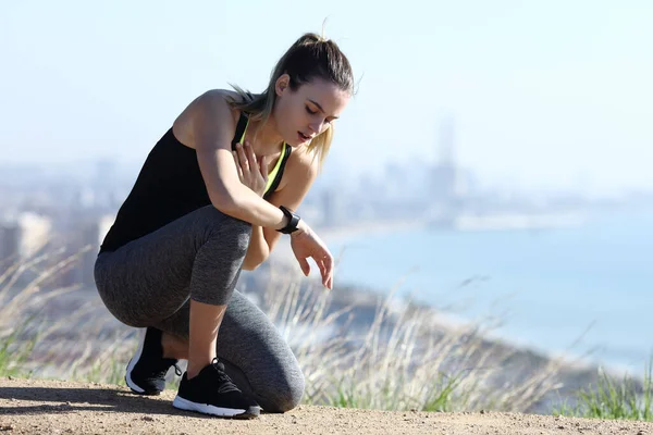 Yorgunluktan boğulmuş koşucu şehrin dışında bir yerde nabız yokluyor ve göğse dokunuyor.