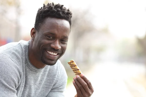 快乐的黑人男子拿着燕麦条准备吃东西 在一个有复制空间的公园里看着摄像机 — 图库照片