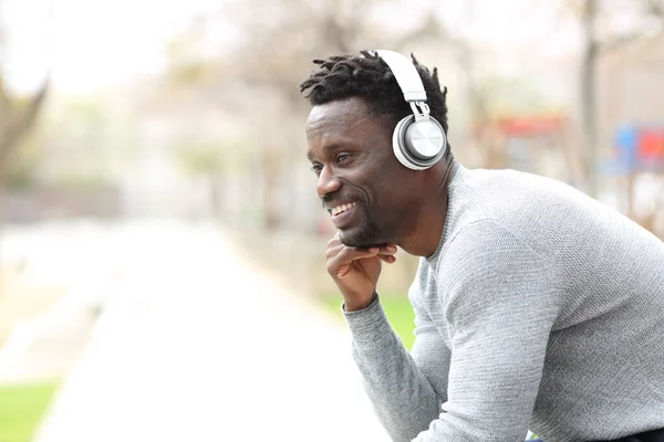 快乐的黑人男人带着耳机听音乐 — 图库照片