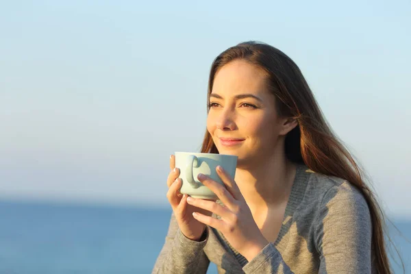 Uvolněná Žena Pije Kávu Při Pohledu Obzor Pláži Při Západu — Stock fotografie