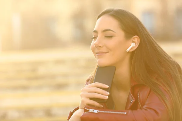 Kulaklık Takan Rahat Bir Kadın Akıllı Telefondan Müzik Dinliyor Gözleri — Stok fotoğraf