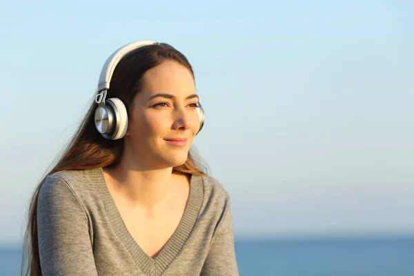 Gün Batımında Plajda Müzik Dinleyen Kulaklık Takan Rahat Bir Kadın — Stok fotoğraf