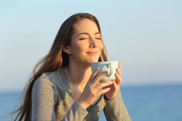 Spokojená Žena Zavřenýma Očima Pije Kávu Při Západu Slunce Pláži — Stock fotografie