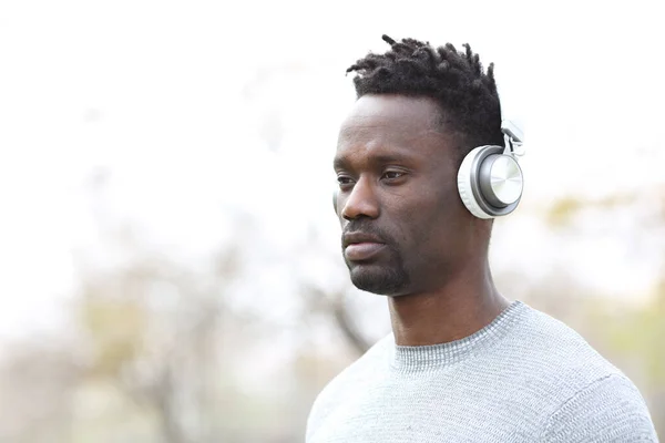 Hombre Negro Serio Escuchando Música Usando Auriculares Inalámbricos Aire Libre —  Fotos de Stock