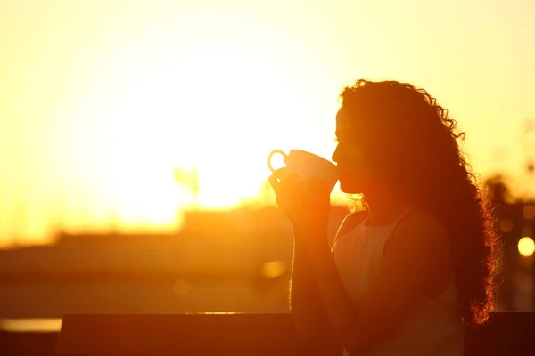 Силуэт Женщины Пьющей Кофе Сидящей Скамейке Закате — стоковое фото