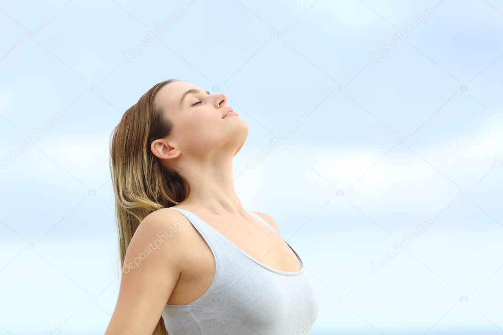 Relaxed girl breathing fresh air on summer with the sky in the background