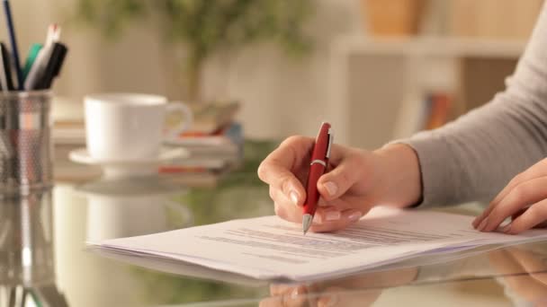 女性の手を閉じて家の机の上に書類を確認して署名する — ストック動画