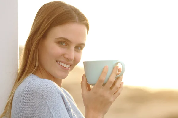 Mujer Feliz Mirando Cámara Sosteniendo Una Taza Café Playa Atardecer — Foto de Stock