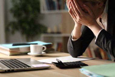 Girişimci kadın geceleri ofis masasında otururken kötü sonuçlardan yakınıyor.