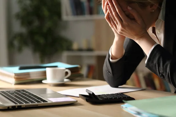 Girişimci kadın geceleri ofis masasında otururken kötü sonuçlardan yakınıyor.