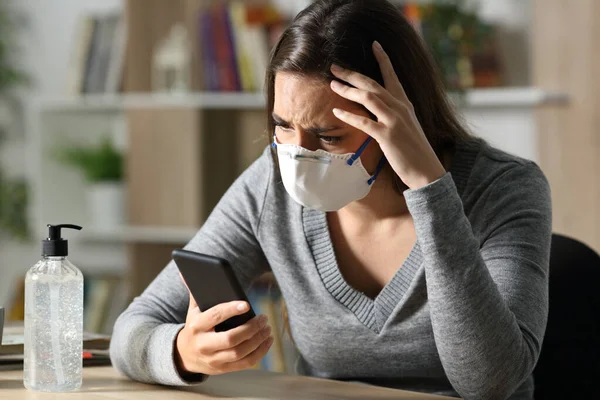 Worried Woman Protective Mask Reads Covid News Smart Phone Sitting — Stock Photo, Image