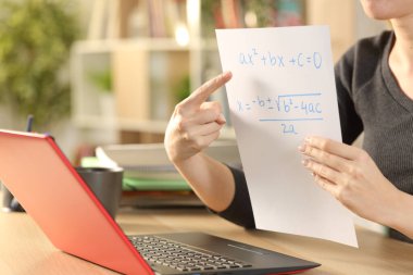 Kadın öğretmenlerin elleri çevrimiçi ders verirken evdeki bir masada görüntülü konuşma yapmak.