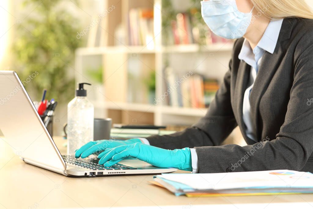 Close up of freelance woman hands avoiding coronavirus rearing mask and latex gloves works on laptop at home office