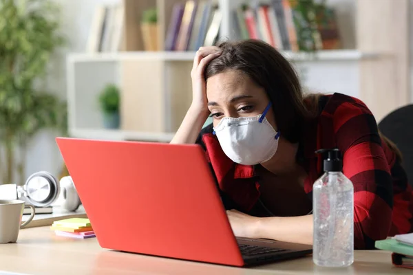 Studentessa Annoiata Con Maschera Guardando Computer Portatile Seduto Una Scrivania — Foto Stock