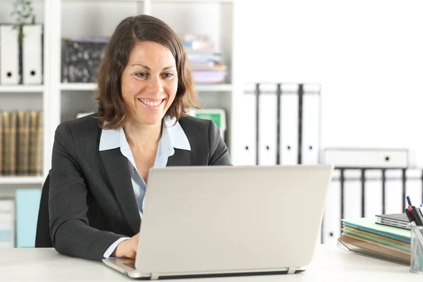 オフィスの机の上に座ってノートパソコンで働く幸せな幹部の女性 — ストック写真