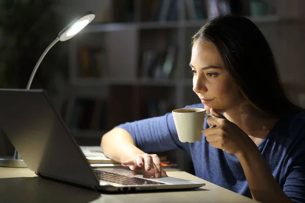 Komoly Aki Laptoppal Tartja Kávéscsészét Egyedül Egy Asztali Lámpával Asztalon — Stock Fotó