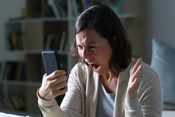 Θυμωμένη Ενήλικη Γυναίκα Φωνάζει Κοιτάζοντας Έξυπνο Τηλέφωνο Κάθεται Στο Σαλόνι — Φωτογραφία Αρχείου