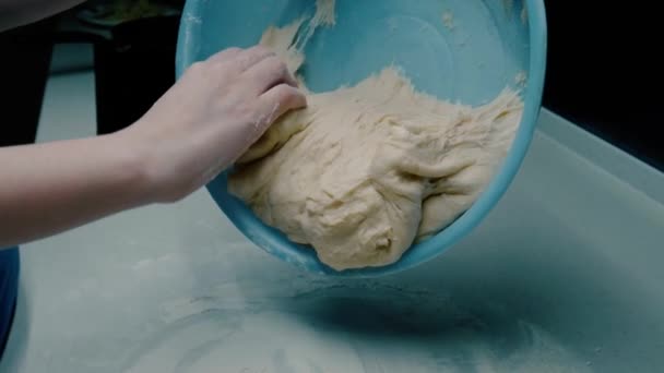 Девушка кладет готовое тесто на стол — стоковое видео