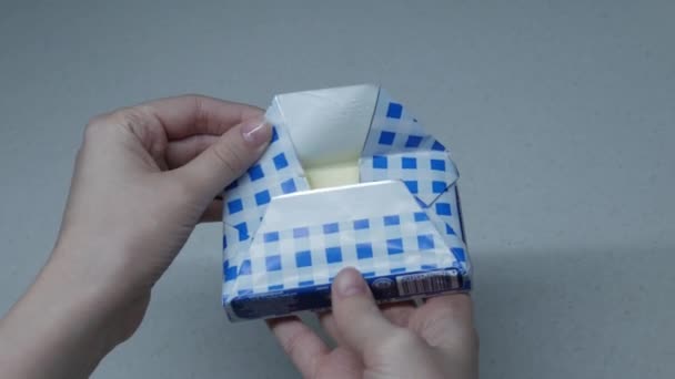 A menina abre um pacote de manteiga — Vídeo de Stock
