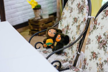 Izmail, Ukraine - 2017. Two soft toys on chair. Famous Russian cartoon character - Cheburashka.  clipart