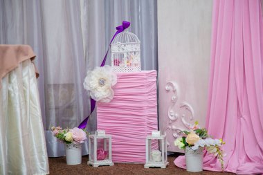 Çiçekli, fenerli ve kuş kafesli pembe ve beyaz süslemeler. Doğum günü veya düğün partisi için.