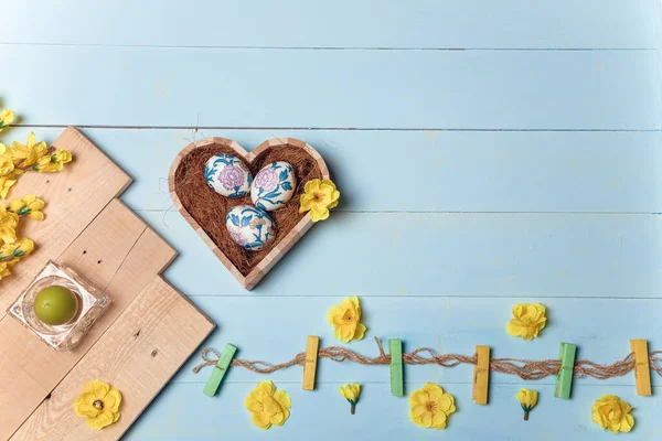 Herzförmige Schachtel Mit Verzierten Ostereiern Gelben Blumen Brennender Kerze Und — Stockfoto