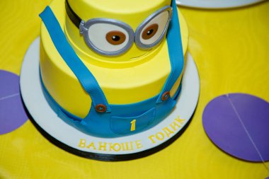 İzmail, Ukrayna - 2016. Editör kullanımı. Minion şeklinde doğum günü pastası. Çocuk partisi için çizgi film karakteri pastası. Tematik olay. Şeker çubuğu.