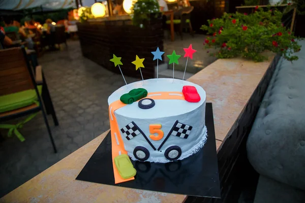 Birthday cake with mastic stars and cars figures for boy. 5 years old anniversary.