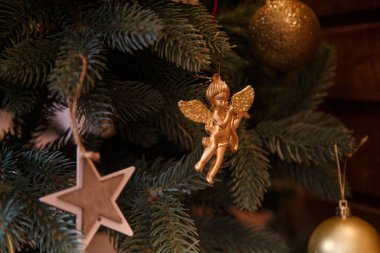 Altın melek oyuncağı Mutlu Noel ağacında asılıydı. Ampulleri ve yıldızları vardı. Kış tatili kavramı.