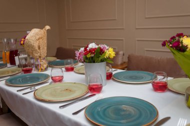 Sonbahar çiçekleri buketleri, kasımpatılar, tabaklar, çatal bıçak takımı, peçeteler, tuz ve biber kapları ve şarap ya da bardakta meyve suyu içeren şenlik masası..