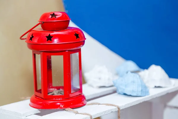 Thematic sea party decorations, red lantern, unfocused blue painted sea shells. Boy birthday party. Soft focused shot, place for text.