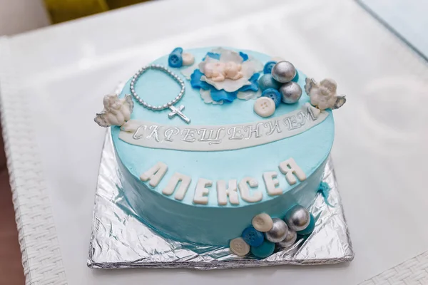 Blue cake with mastic cross and angels for boy christening party. Inscription - Baptism of Alexey.