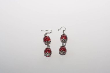 Beyaz arka planda el yapımı yuvarlak küpeler. Kadın aksesuarları, dekoratif süsler ve mücevherler. Moda ve tarz kavramı.