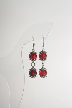 Beyaz arka planda el yapımı yuvarlak küpeler. Kadın aksesuarları, dekoratif süsler ve mücevherler. Moda ve tarz kavramı.