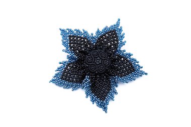 Mavi ve siyah boncuklar el yapımı çiçek broşu beyaz arka planda izole edilmiş. Kadın aksesuarları, dekoratif süsler ve mücevherler. Moda ve tarz kavramı.