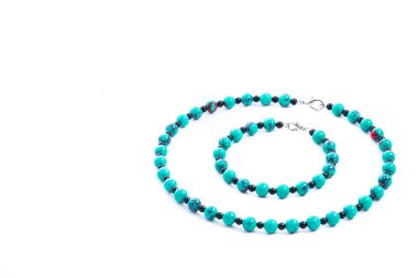 Beyaz arka planda izole edilmiş turkuaz kolye ve bilezik seti. Kadın aksesuarları, dekoratif süsler ve mücevherler. Moda ve tarz kavramı.