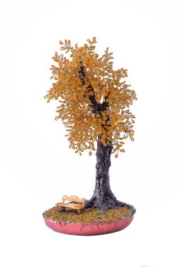 Altında dekoratif bank olan bonzai ağacı. Beyaz arkaplanda el yapımı bir hatıra..