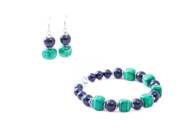 Beyaz arka planda izole edilmiş yeşil küpe ve bilezikler. Kadın aksesuarları, dekoratif süsler ve mücevherler. Moda ve tarz kavramı.