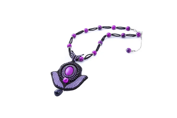 Beaded purple necklace with pendant isolated on white background. Female accessories, decorative ornaments and jewelry. Fashion and style concept.