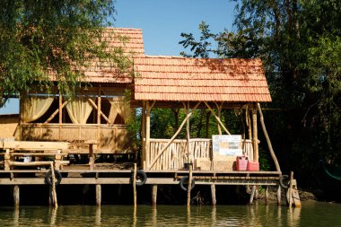 VIlkovo, Ukrayna - Ağustos 2019. Nehrin güzel manzarası, yeşil doğa ve mavi gökyüzü olan deniz kenarındaki binalar..