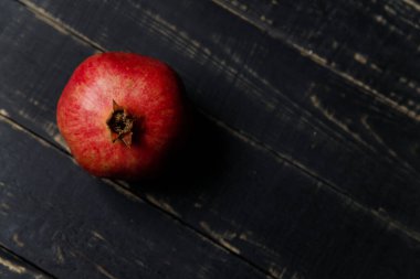 Siyah ahşap arka planda nar meyvesi. Boşluğu kopyala.