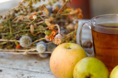 Kuru şifalı ot buketi, bir fincan bitki çayı ve biraz taze meyve, elma ve armut.. 