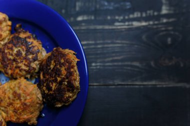 Mavi tabakta et ve havuç pirzolası siyah ahşap arka planda duruyor. Lezzetli ve sağlıksız yemekler. Diyet, beslenme, yeme alışkanlıkları. Metin için yer