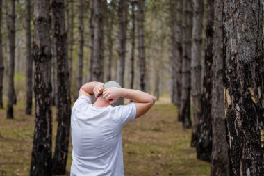 Çam ormanında gaz maskesi çıkaran bir adam. Çevre koruma, ekoloji, Dünya kurtarma, kirliliği önleme, kriz, sağlık kavramı. 