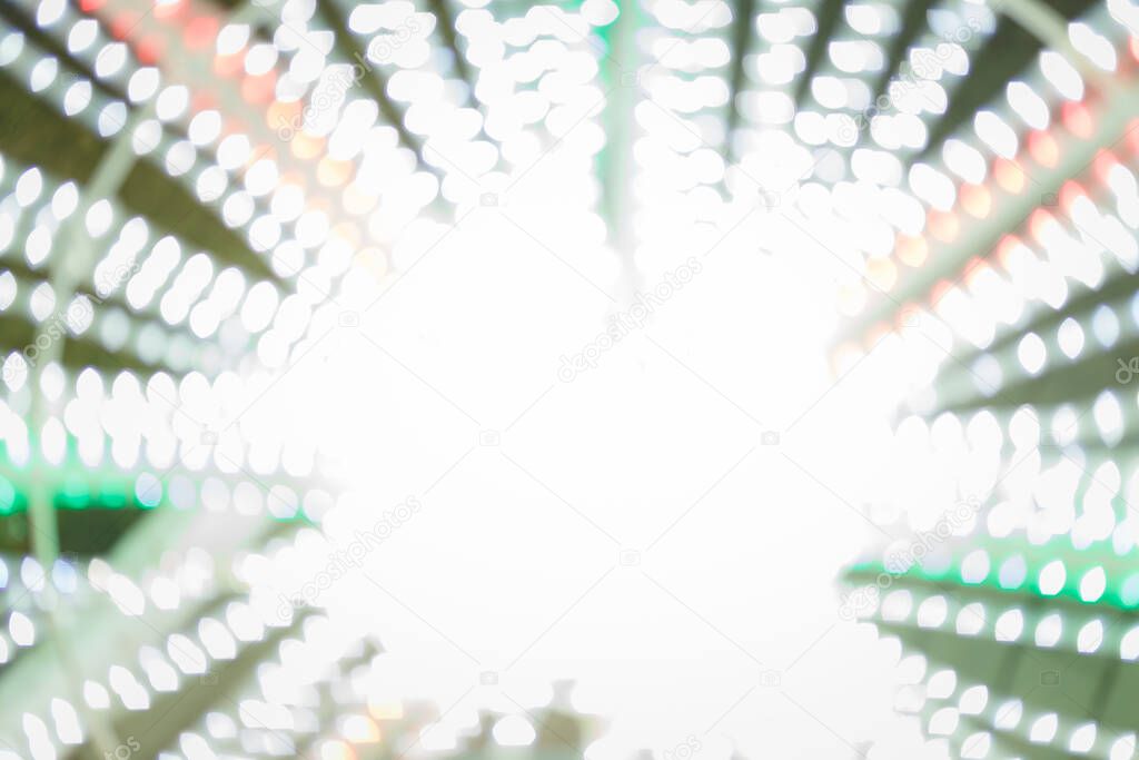 Unfocused night shot of Christmas garland lights bokeh in the city. Happy New Year, Merry Christmas, winter holidays concept.