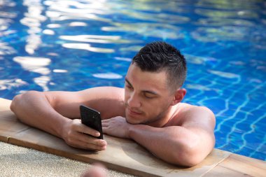 genç yakışıklı bir telefonla Havuzu