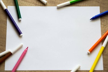 Kağıt, renkli keçeli kalem ahşap arka plan üzerinde beyaz sayfa