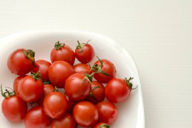 Beyaz bir arka plan üzerinde beyaz bir tabakta domates